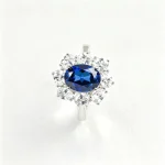 Top-down view of lab-grown blue sapphire sunflower halo ring with lab-created diamond halo, oval cut center stone