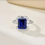 close up detail of lab grown blue sapphire emerald cut ring halo setting S925 silver