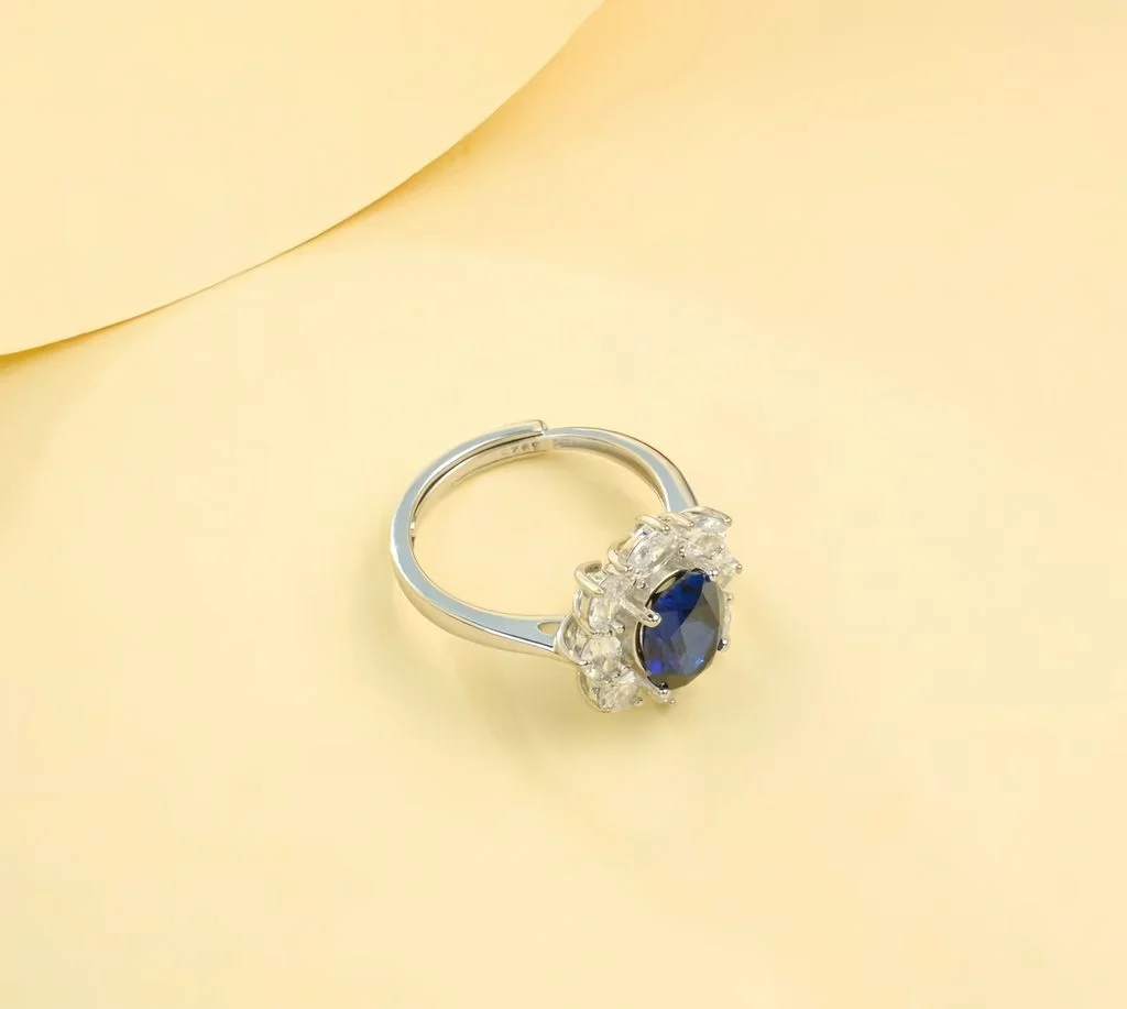 Side profile view of lab-grown blue sapphire sunflower halo engagement ring, showing band thickness and S925 hallmark stamped on inside of band