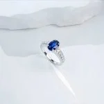 lab grown oval blue sapphire pave ring S925 sterling silver on soft fabric background bokeh