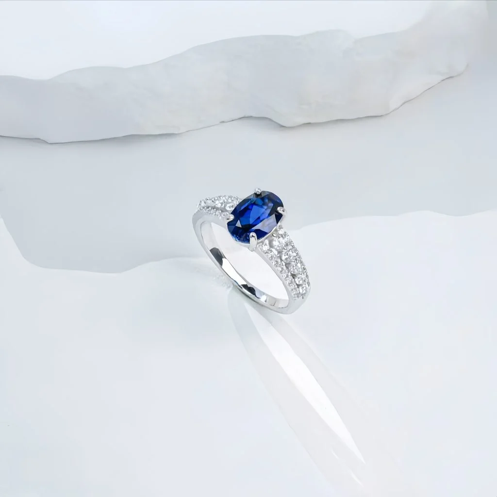 lab grown oval blue sapphire pave ring S925 sterling silver on white silk fabric background bokeh