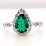 close up detail of lab grown emerald green pear diamond halo ring S925 sterling silver milgrain