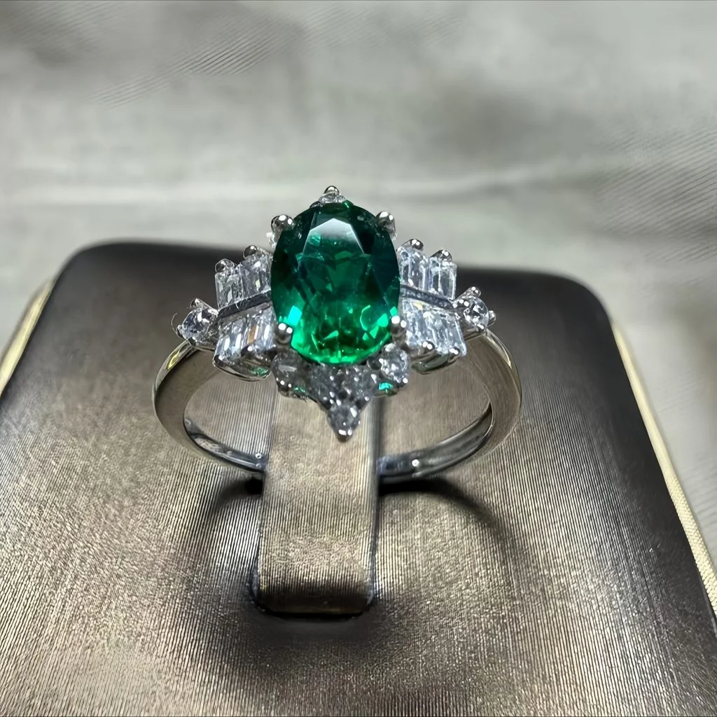 lab grown vintage crown emerald ring S925 sterling silver top-down flat lay view oval cut green gemstone baguette round diamond crown setting adjustable open band