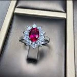 lab grown pigeon blood ruby Diana halo ring S925 sterling silver displayed in jewelry box oval cut red gemstone round diamond cluster halo