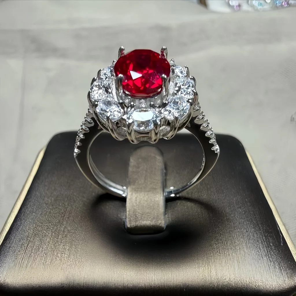 lab grown sunflower halo ruby ring S925 sterling silver top-down flat lay view oval cut red gemstone pear shaped diamond petals jewelry box