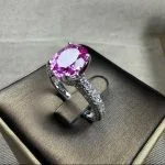 lab grown padparadscha sapphire oval ring S925 sterling silver worn on hand pavé halo setting lotus pink orange gemstone