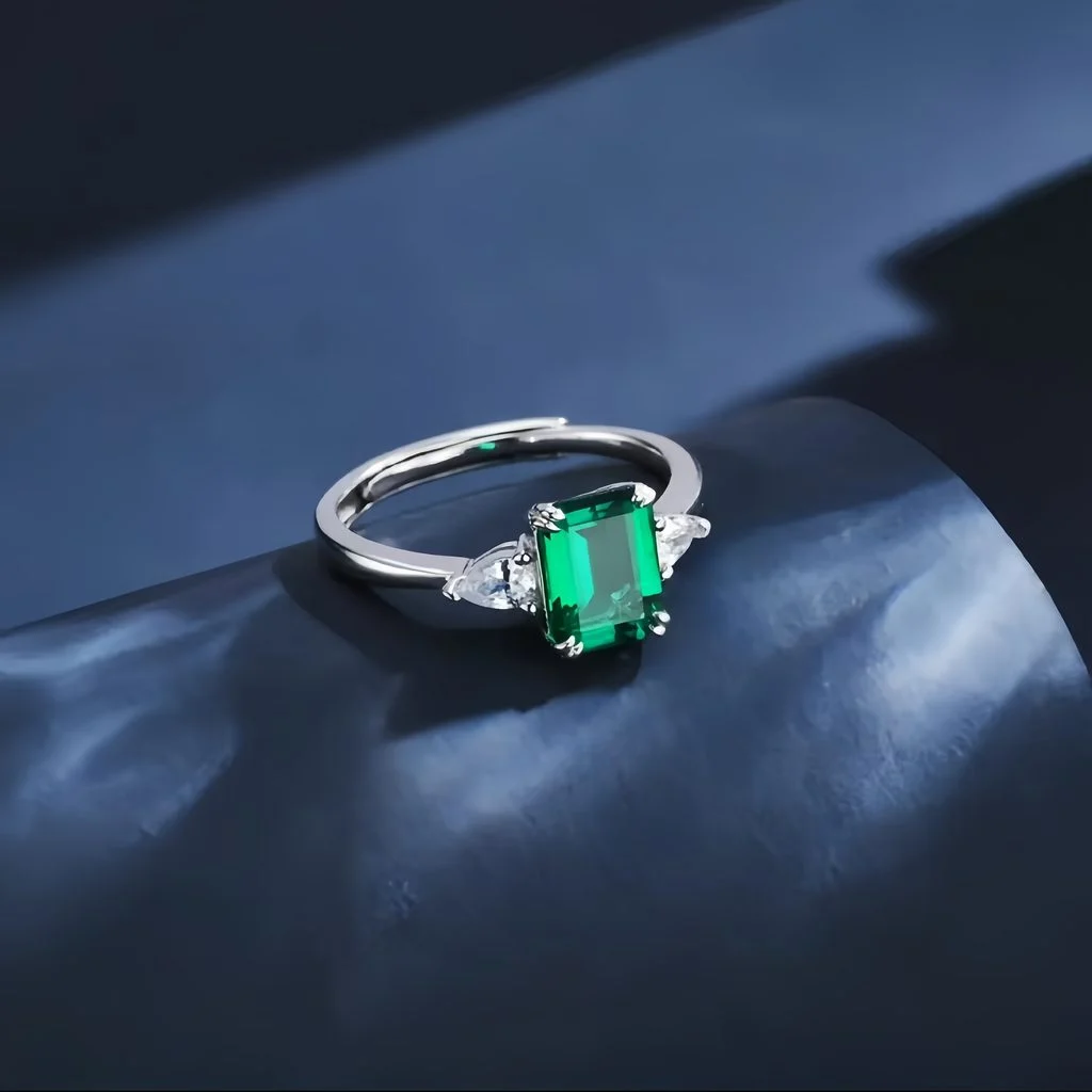 lab grown emerald three stone ring S925 sterling silver presented in jewelry box emerald cut green gemstone pear shaped diamond accents full trilogy design