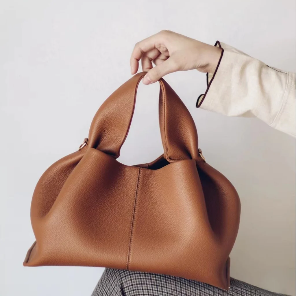 Vintage suede cloud dumpling bag in dark brown worn on shoulder, retro soft handbag