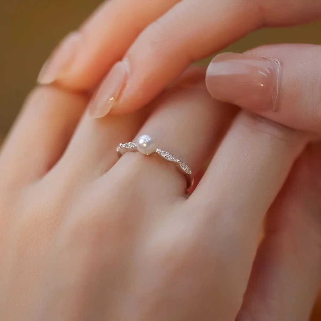 Dainty freshwater pearl ring with leaf CZ band in 925 sterling silver, worn on finger