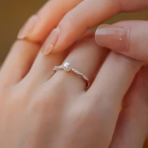 Dainty freshwater pearl ring in 925 sterling silver with leaf CZ band, worn on finger
