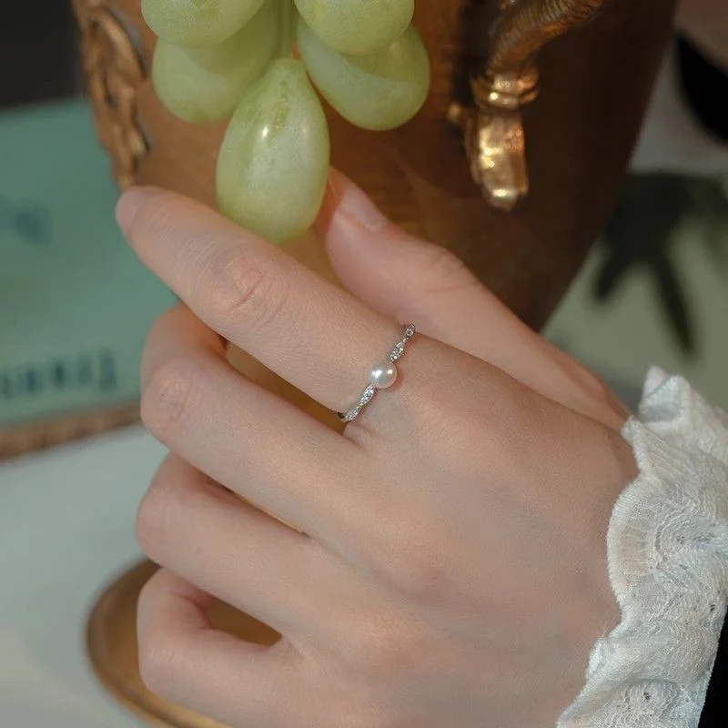 Woman wearing freshwater pearl ring holding rose, romantic lifestyle jewelry photography