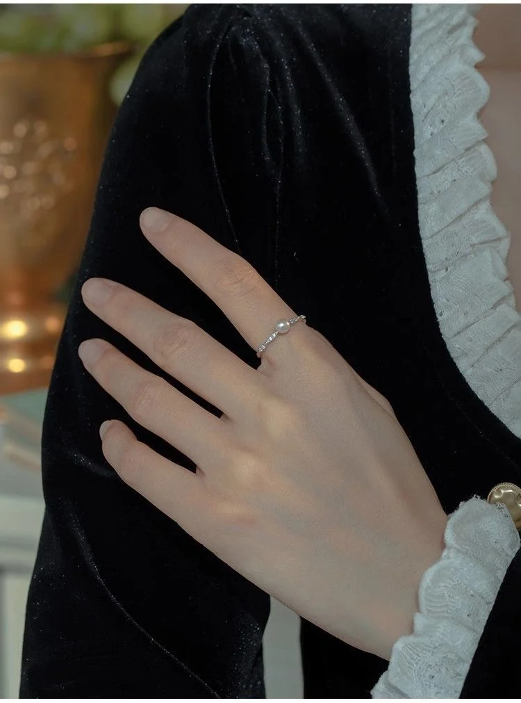 Dainty freshwater pearl ring on hand with grapes, elegant lifestyle jewelry aesthetic shot