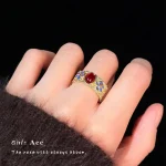 Vintage gold ring with red oval gemstone worn on finger, medieval style CZ accent ring