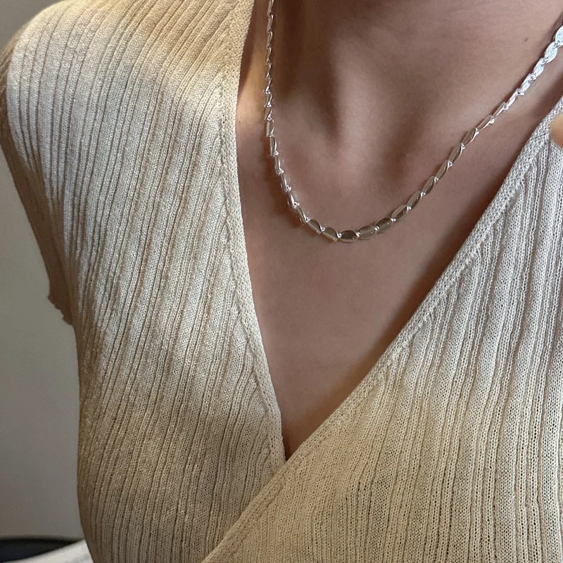 Model wearing S925 sterling silver brushed bean necklace styled with beige knit, minimalist jewelry styling by MAISON ELARA & CO