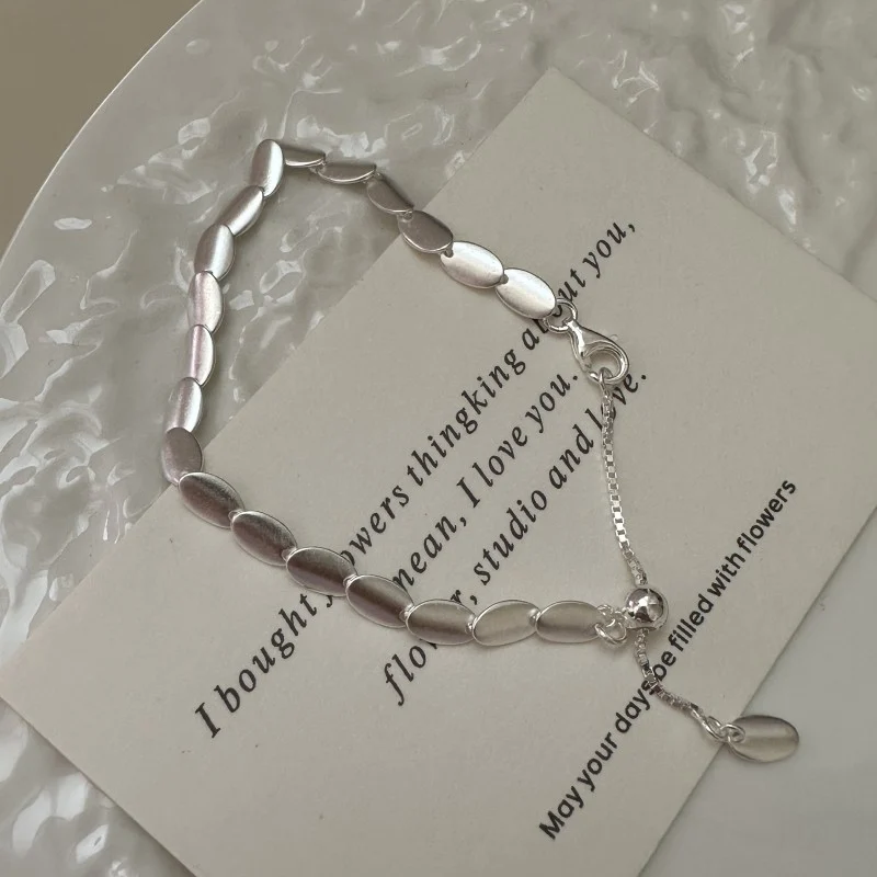 Close-up of S925 silver brushed bean necklace drawstring clasp with leaf brand tag, adjustable detail shot