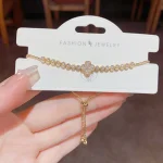 Gold-tone zircon four-leaf clover bracelet worn on wrist showing sparkling champagne zircon stones in tennis bracelet design, delicate minimalist jewelry for everyday wear