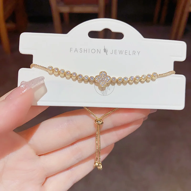 Gold-tone zircon four-leaf clover bracelet, sparkling champagne stones in tennis bracelet design by MAISON ELARA & CO