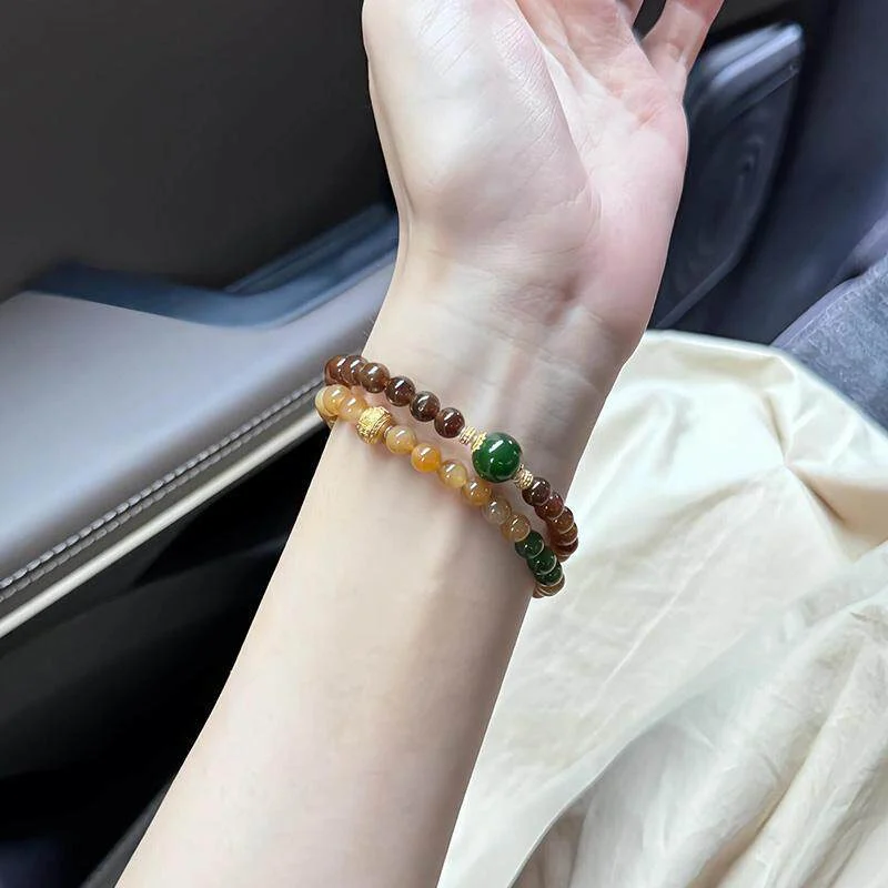 Lifestyle shot, Hetian Qiemo sugar jade double‑strand bracelets stacked on female wrist, matching casual outfit, quiet old‑money gemstone jewelry
