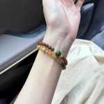 Woman wearing caramel gradient Hetian jade beaded bracelet on wrist, natural jade stone everyday jewelry lifestyle shot