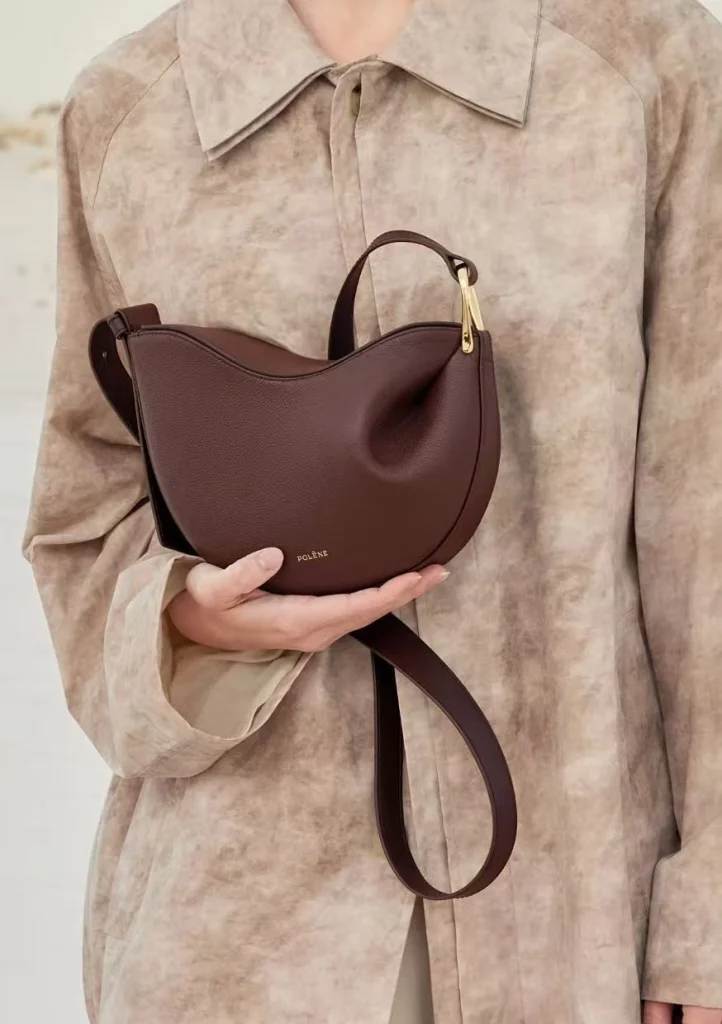 Dark brown genuine leather pea hobo bag, model holding luxury women crossbody purse