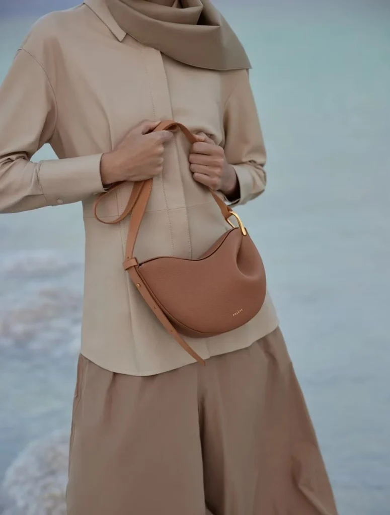 Model wearing tan genuine leather pea hobo crossbody bag seaside fashion shot