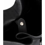 Interior close‑up view of oversized top‑grain leather bucket bag, showing inner structure and strap rivet detail
