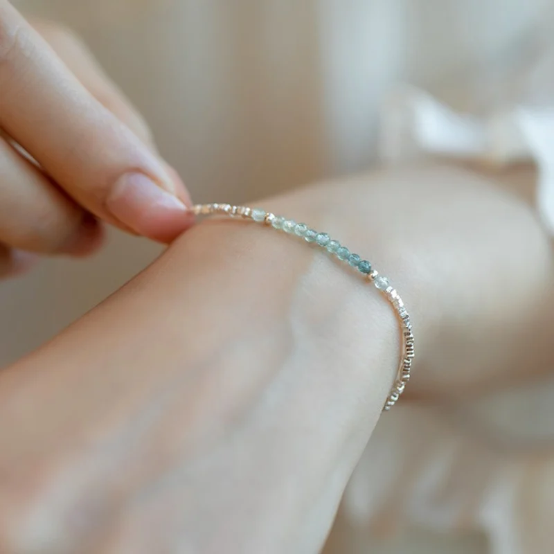 Dainty hand‑strung tourmaline 925 silver bracelet worn on female wrist, everyday layering jewelry