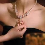 Model holds dangling pearl pendant of vintage flower‑vine zircon pearl choker women formal clavicle necklace