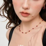 Close‑up shot of women wearing faceted red agate station collarbone necklace, fine gold‑tone chain french vintage jewelry