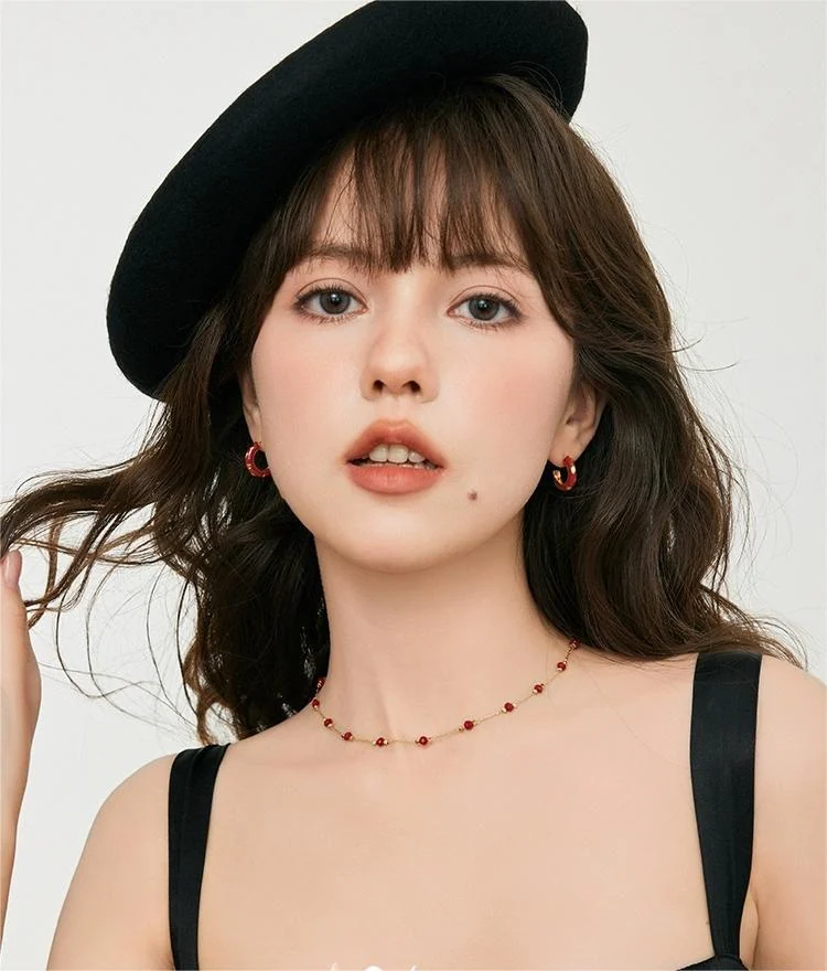 Woman with black beret wearing french vintage red agate station choker and red hoop earrings