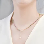 Woman wearing rainbow tourmaline cube choker with pearl drop detail, elegant layering crystal collarbone necklace