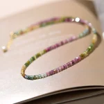 Rainbow tourmaline cube bead choker laid on book, dainty natural crystal women collarbone necklace
