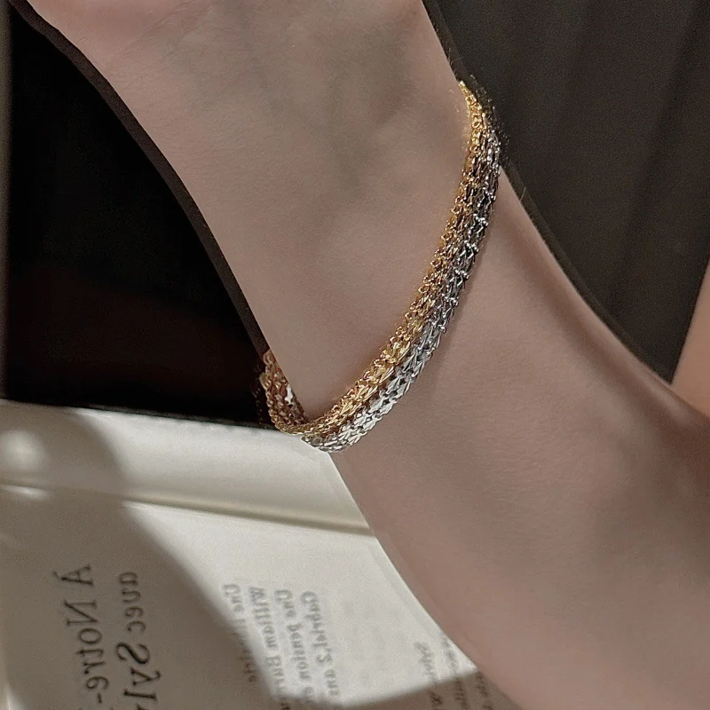 Close-up shot of polished silver S999 shell textured chain bracelet held between fingers, showing heart extender and hook clasp for women’s stacking jewelry