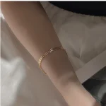 Gold‑toned S999 sterling silver shell geometric bracelet worn on female wrist, dainty French vintage jewelry