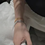 Mixed‑metal stack of gold‑toned and silver S999 three‑row rhombus woven bracelets worn on female wrist, medieval vintage stacking jewelry