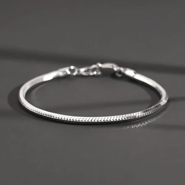 S925 sterling silver octagonal snake chain bracelet studio shot on dark grey background