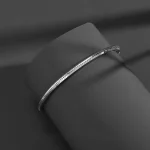 S925 sterling silver octagonal snake chain bracelet laid on dark gray display stand