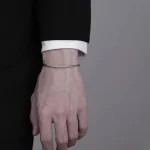 Male model wrist wearing S925 sterling silver octagonal snake chain bracelet with formal suit