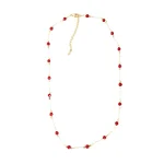 Flat lay dainty gold‑tone station necklace with faceted red agate beads on white background