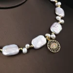 Close‑up detail of baroque freshwater pearl choker with filigree zircon pendant