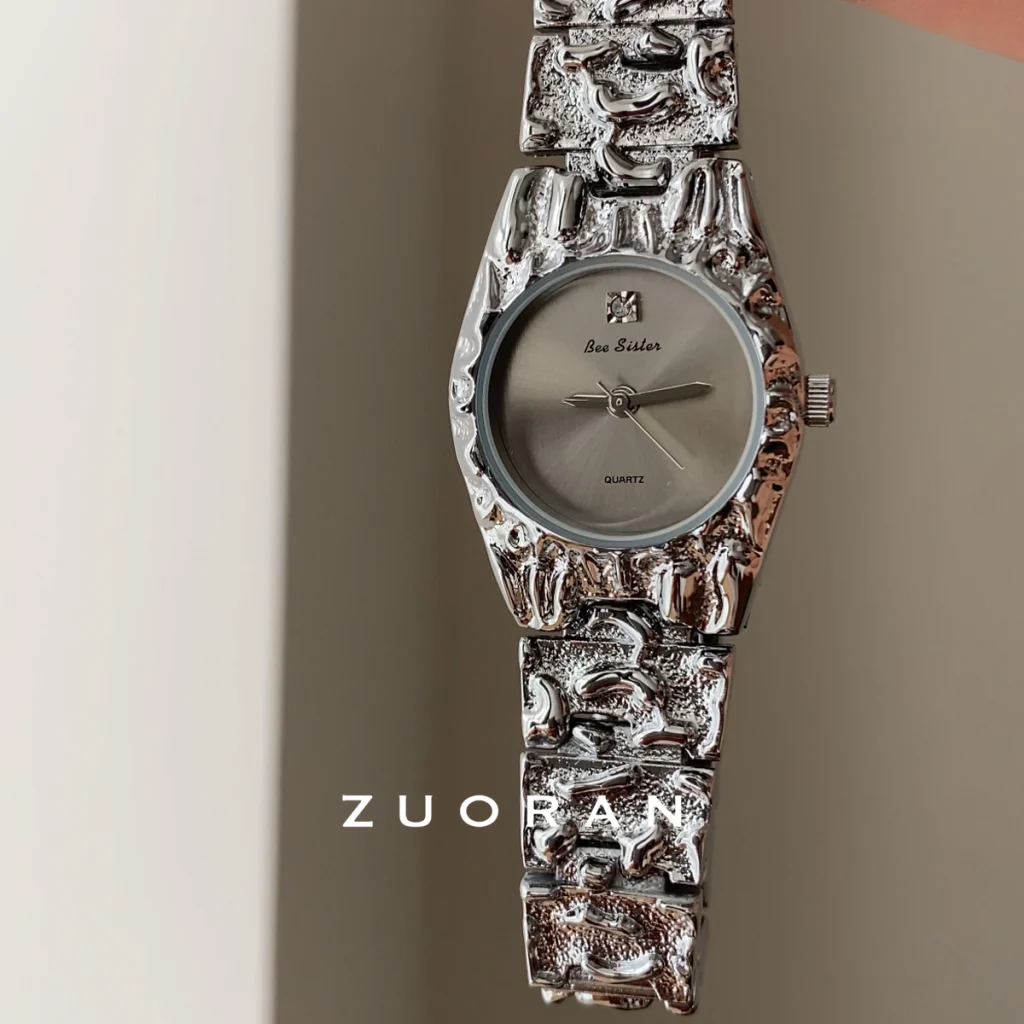 Close-up view of Bee Sister hammered silver watch, irregular textured case and sunburst dial with crystal decoration