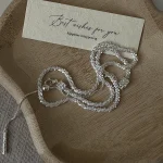 Full set of S925 sterling silver sparkle Y lariat necklace coiled on wooden tray with gift card and jewelry pouch