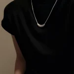 S925 matte crescent silver necklace worn on collarbone with black turtleneck sleeveless top