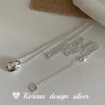Full S925 sterling silver bean pendant necklace laid flat, showing curb chain, extension chain and square tag