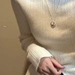S925 hollow donut pendant necklace worn with cream ribbed knit sweater, sweater chain wearing view