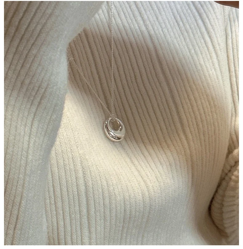 S925 sterling silver hollow circle necklace close-up on cream ribbed sweater, women everyday styling