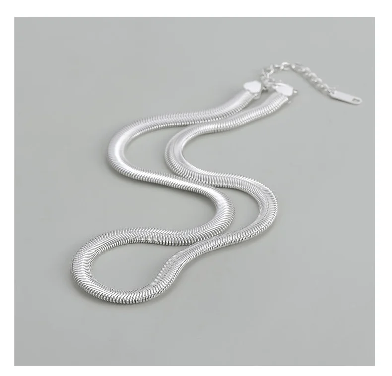Full flat lay of S925 sterling silver flat snake chain necklace, showing lobster clasp and extension chain