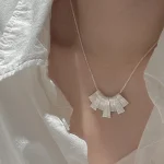 S925 silver fan shape pendant necklace worn on collarbone with white linen shirt, front view everyday styling