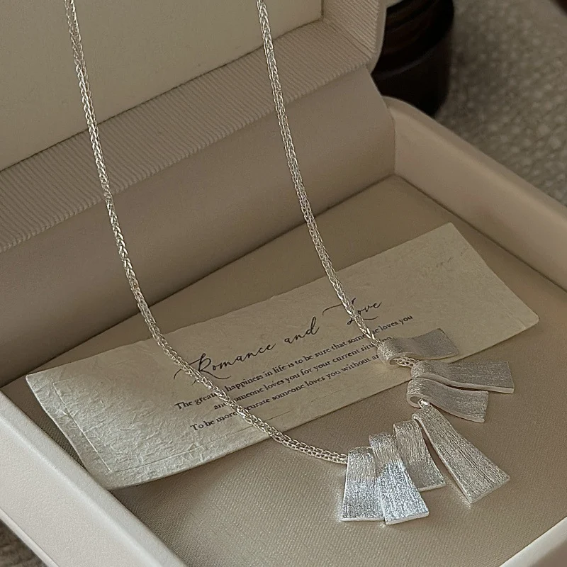 Flat lay of S925 silver fan pendant necklace in jewelry box with vintage greeting card, romantic gifting display