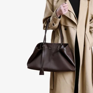 Women chocolate brown soft leather tote bag worn with khaki trench coat, oversized slouchy shoulder bag for office